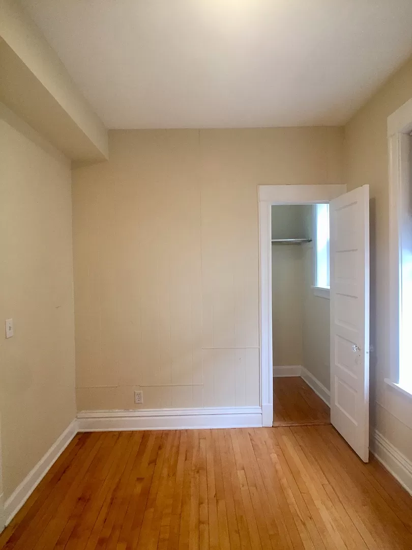 an empty room with a wooden floor and an open door