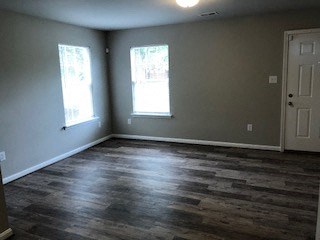 an empty living room with wood floors and a door