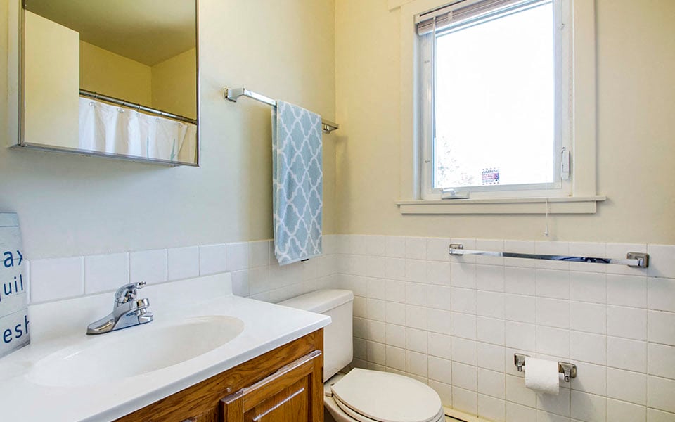 a bathroom with a sink toilet and a window