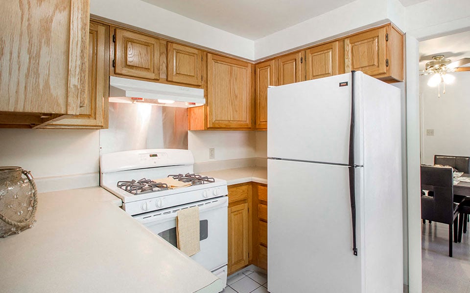a kitchen with white appliances and wooden cabinets