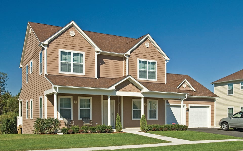 a large suburban house with a lawn in front of it