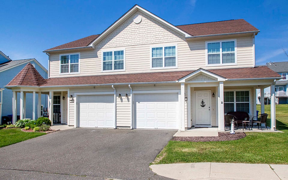 a white house with white doors and a driveway