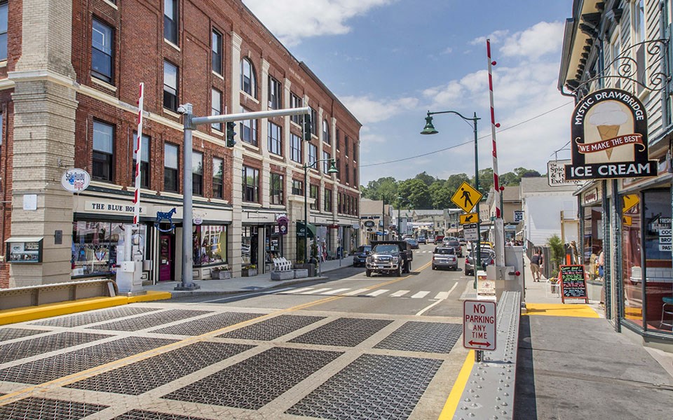 a city street with cars and buildings and a crosswalk