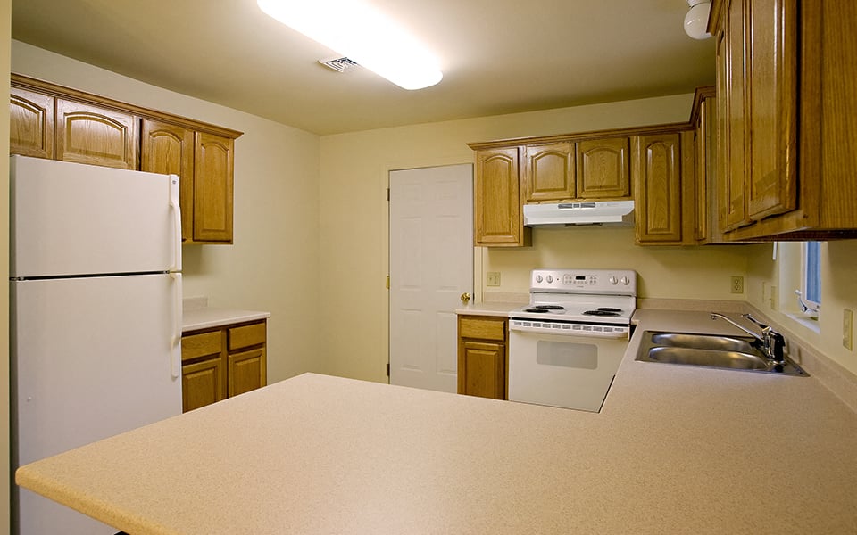 a kitchen with white appliances and wooden cabinets