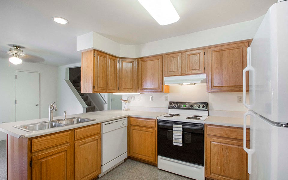 a kitchen with white appliances and wooden cabinets
