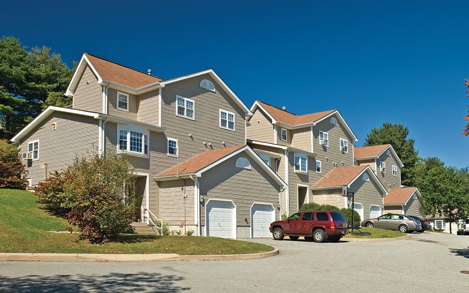 a row of houses with cars parked in front of them