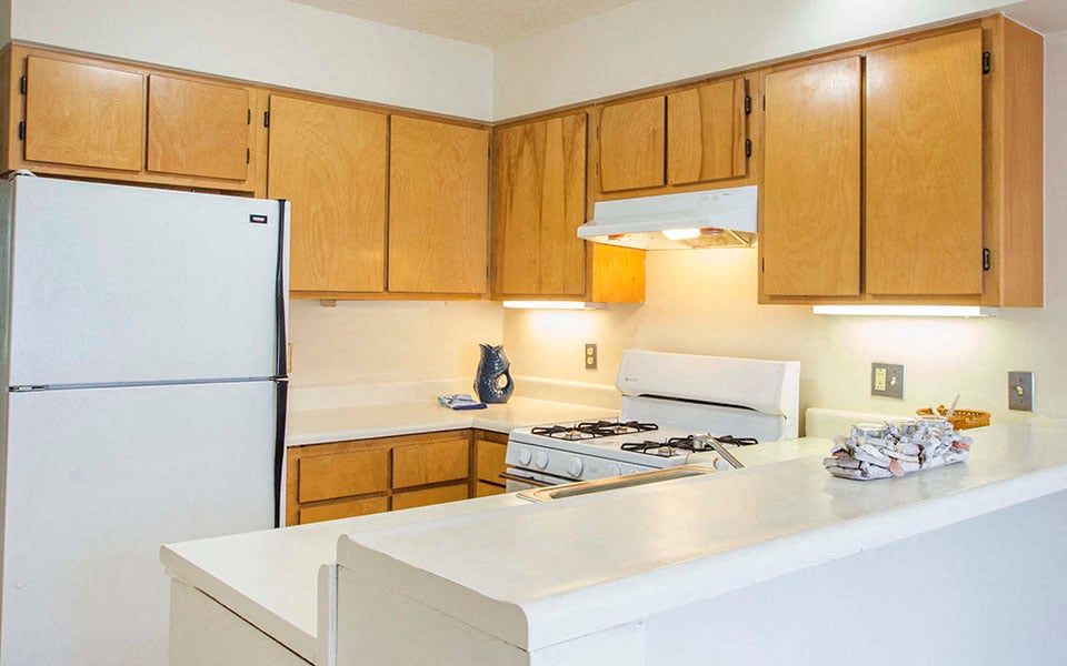 a kitchen with a white counter top and a refrigerator