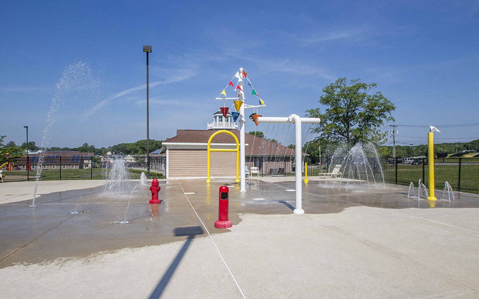a fire hydrant is spraying water at a childrens park