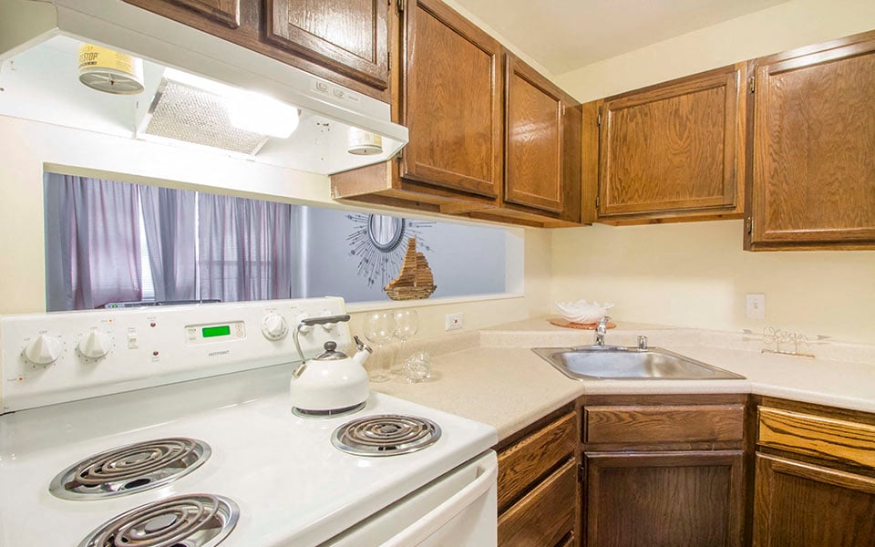 a kitchen with white appliances and wooden cabinets