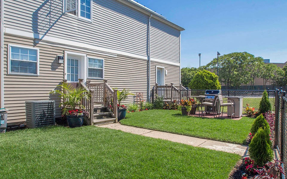 a backyard with a house and a lawn