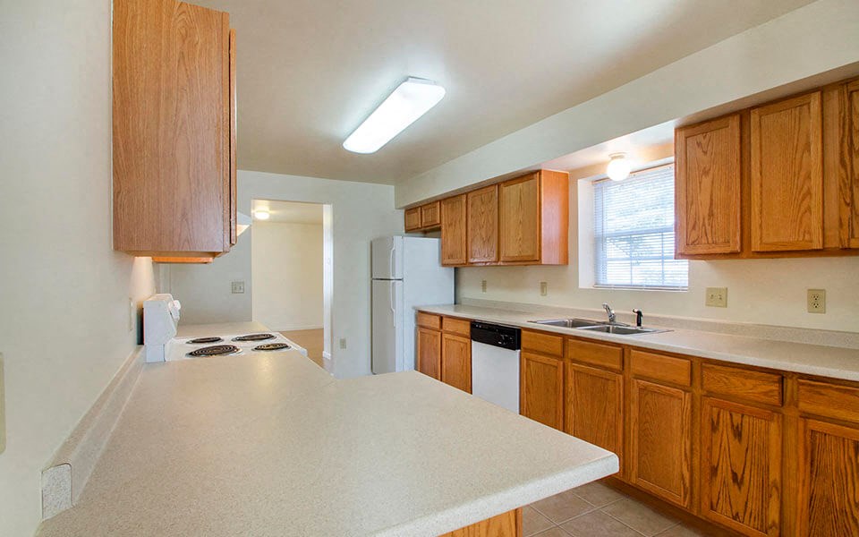 a kitchen with wooden cabinets and a white counter top