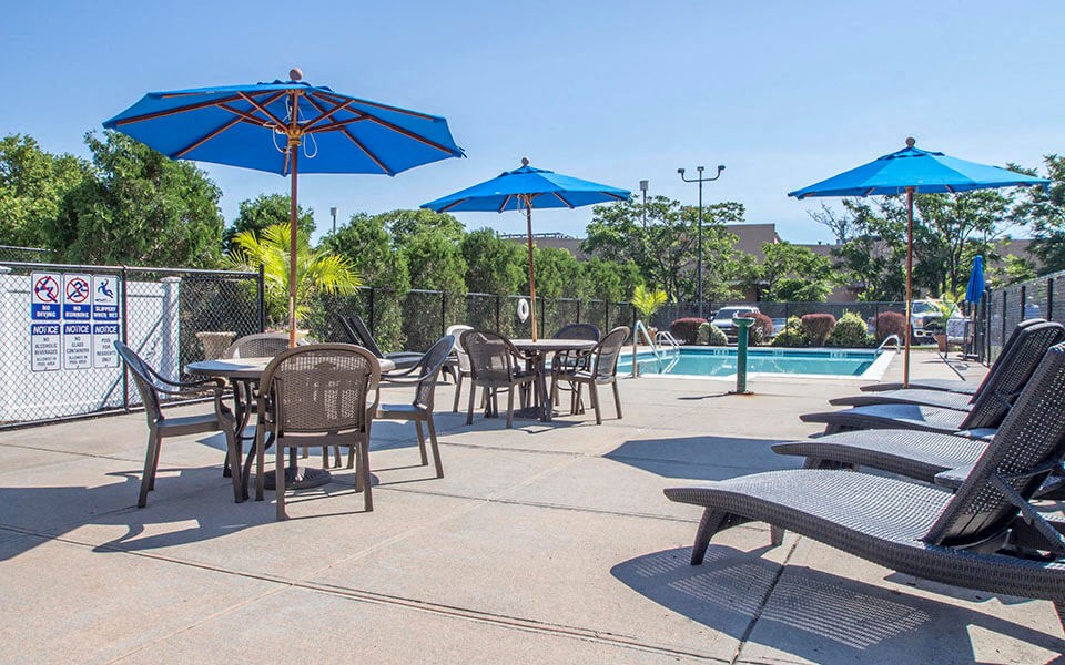 tables with umbrellas next to a swimming pool