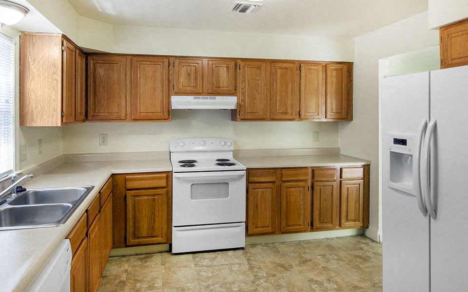 a kitchen with white appliances and wooden cabinets
