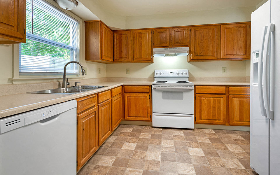 a kitchen with white appliances and wooden cabinets