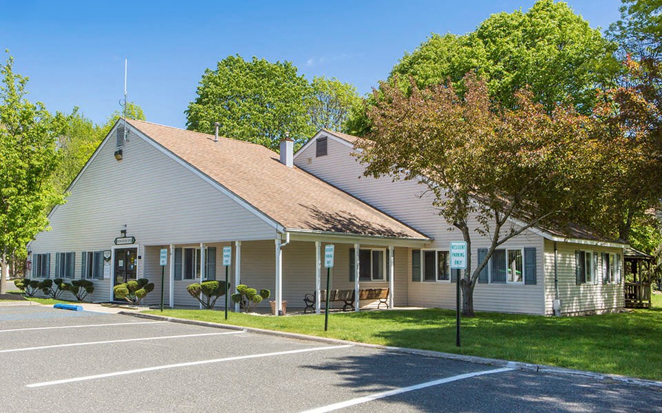 a white house with a porch and a parking lot