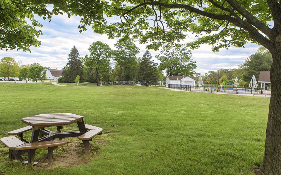a picnic table in a park next to a playground