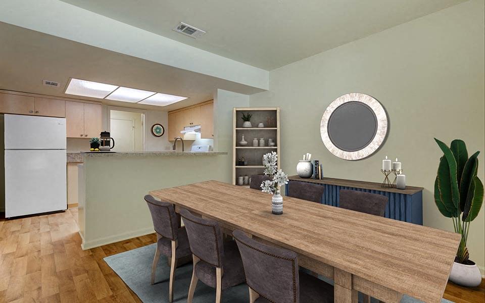 a dining room with a wooden table  and a kitchen