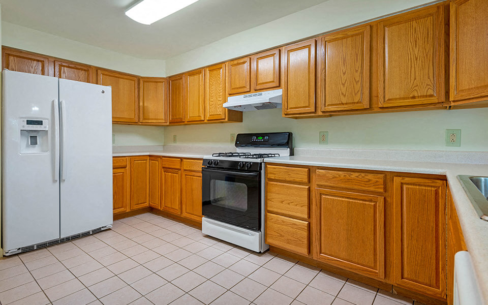 a kitchen with wooden cabinets and a stove and a refrigerator