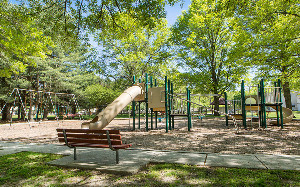 a playground with a slide and a bench