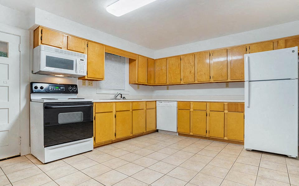 a kitchen with white appliances and wooden cabinets