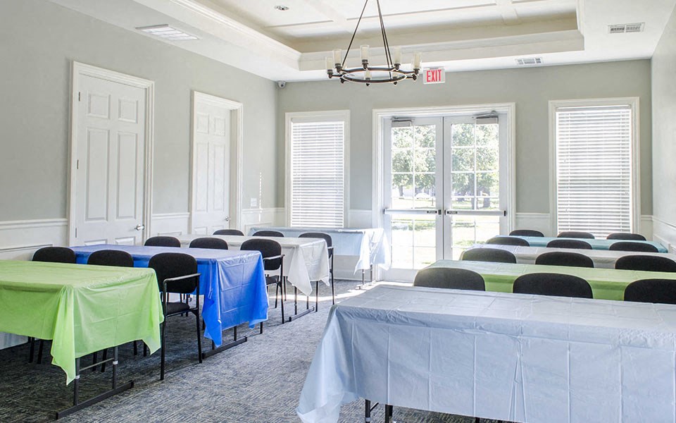 a conference room with tables and chairs and a chandelier