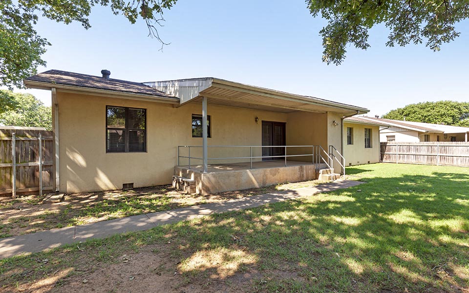a small house with a porch and a yard
