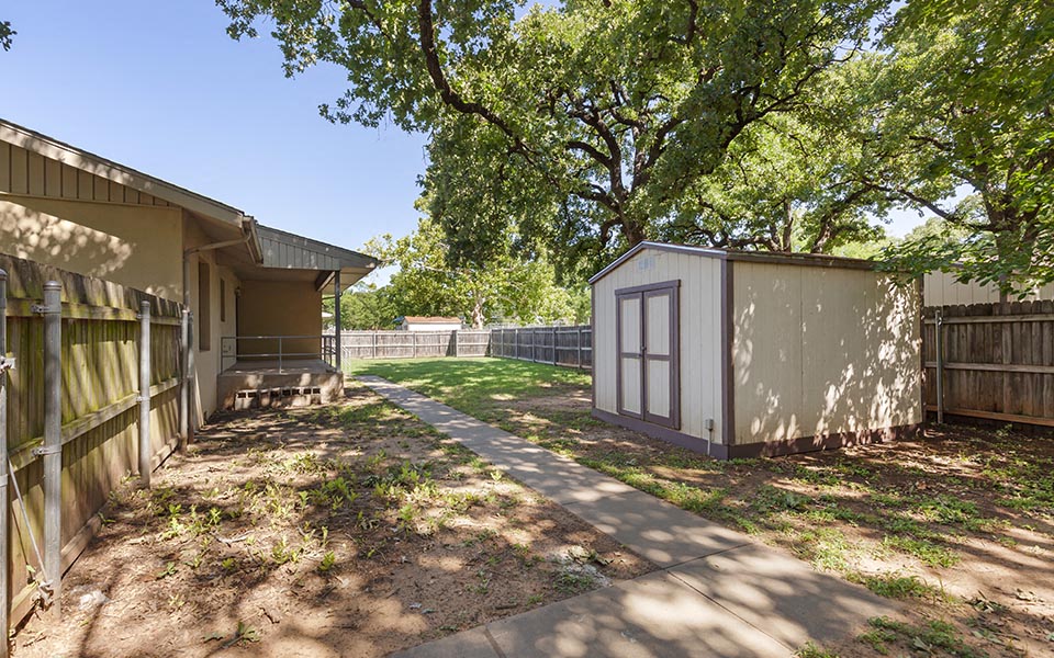 a small yard with a shed and a house