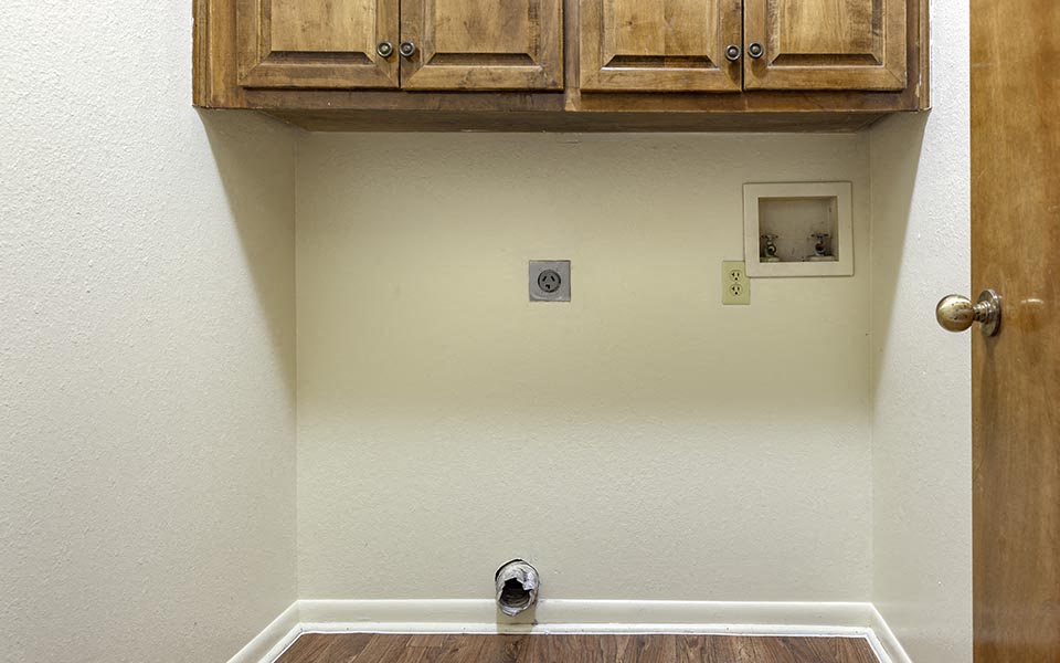 an empty room with wooden cabinets and a door