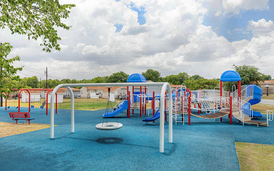 a playground at a park with slides and swings