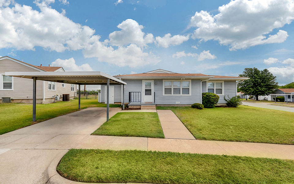 a white house with a lawn and a sidewalk