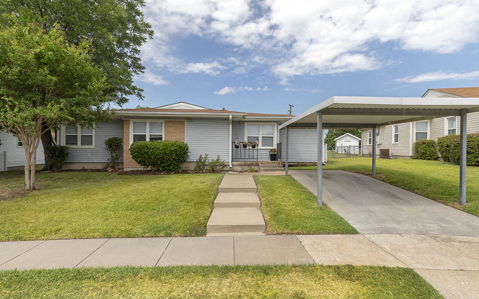 a white house with a sidewalk in front of it
