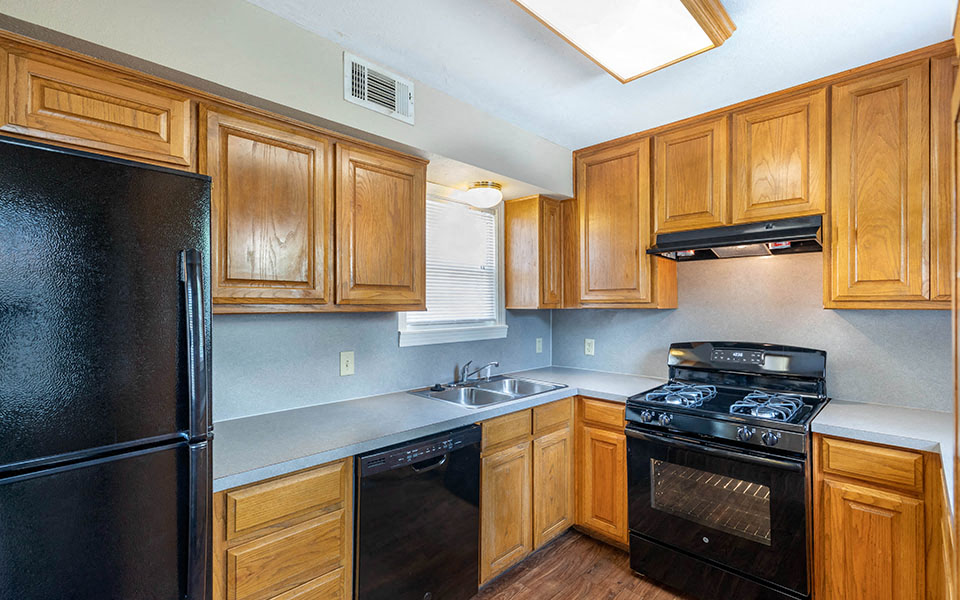 a kitchen with black appliances and wooden cabinets
