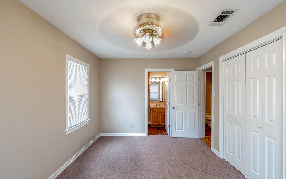 an empty room with white doors and a ceiling fan