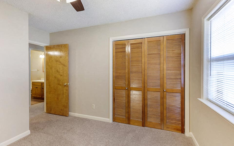 an empty room with a closet and a door
