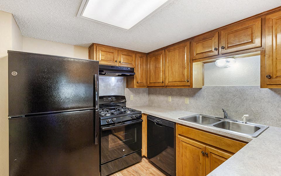 a kitchen with black appliances and wooden cabinets