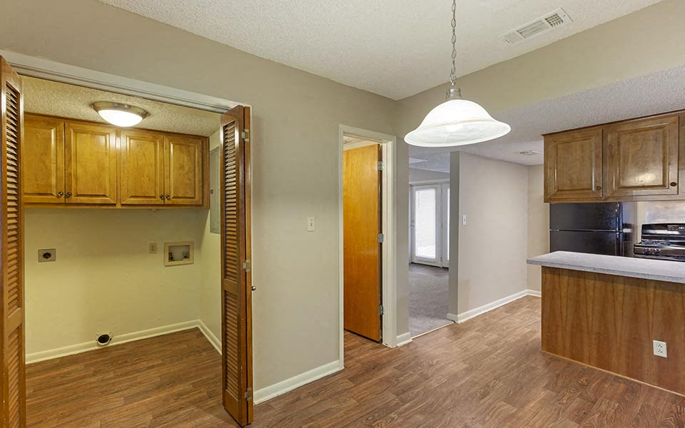 an empty kitchen and living room with wood flooring