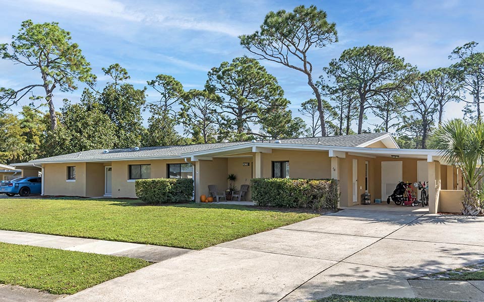 a house with a driveway and a yard in front of it