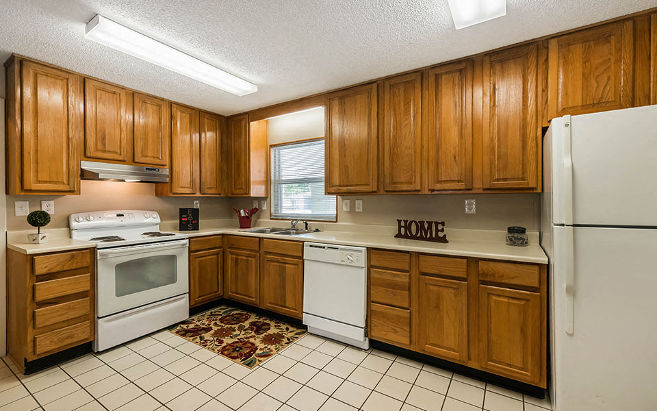 a kitchen with white appliances and wooden cabinets