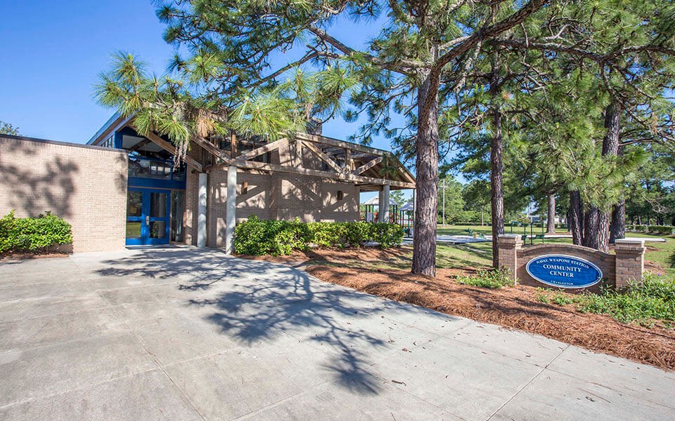 a building with a sign and trees in front of it