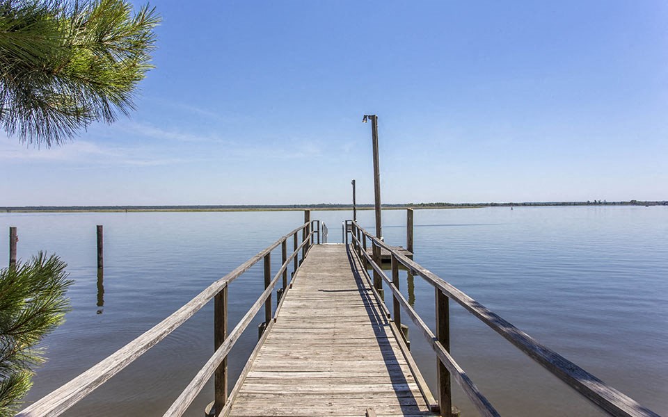 a dock on a lake with a clear blue sky