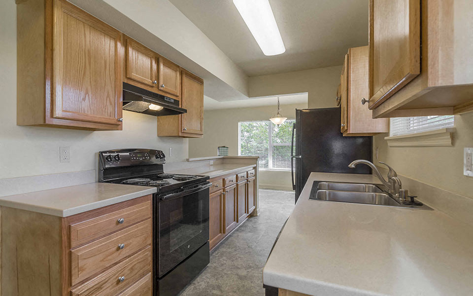 a kitchen with wooden cabinets and black appliances