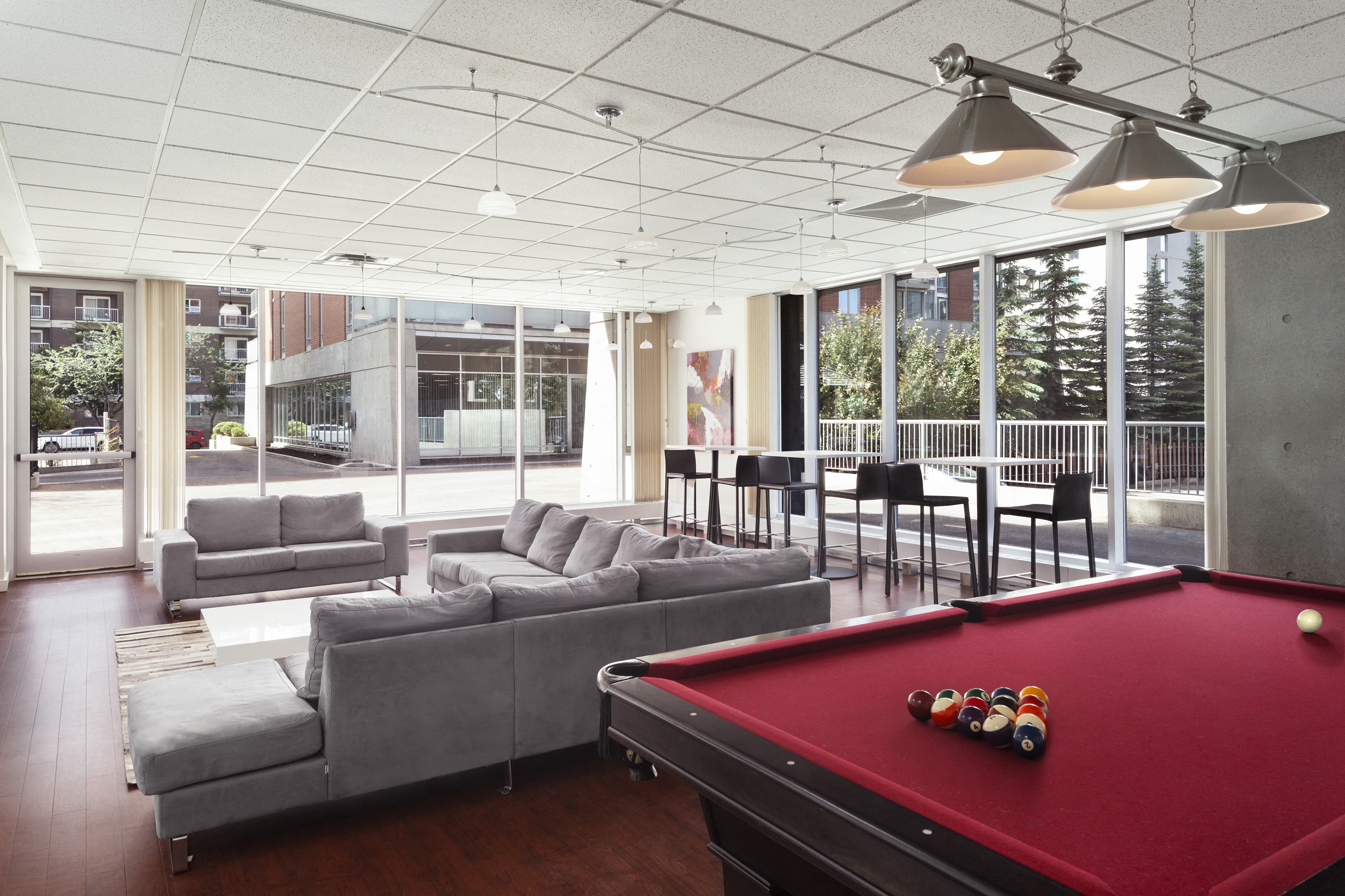 social room with seating, a pool table and large windows