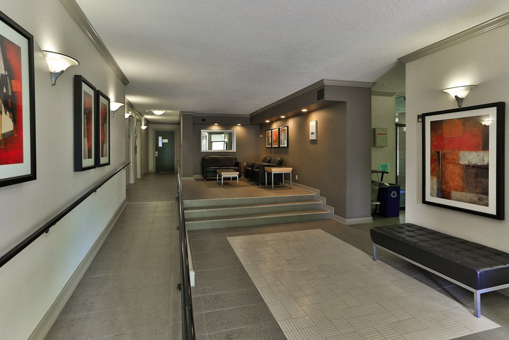 a long hallway with a couch and a table in a hotel room