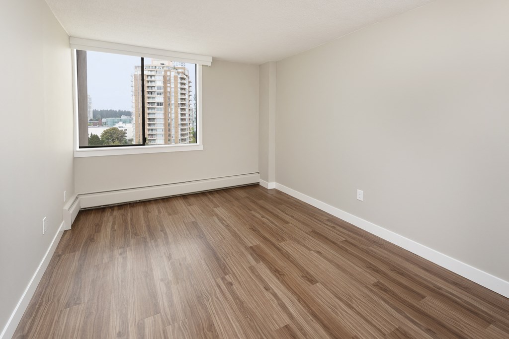 an empty room with wooden floors and a window