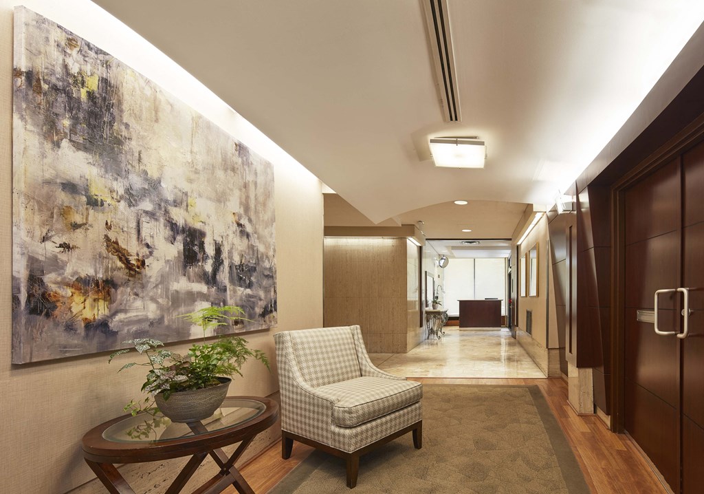 a hallway with a chair and a painting on the wall