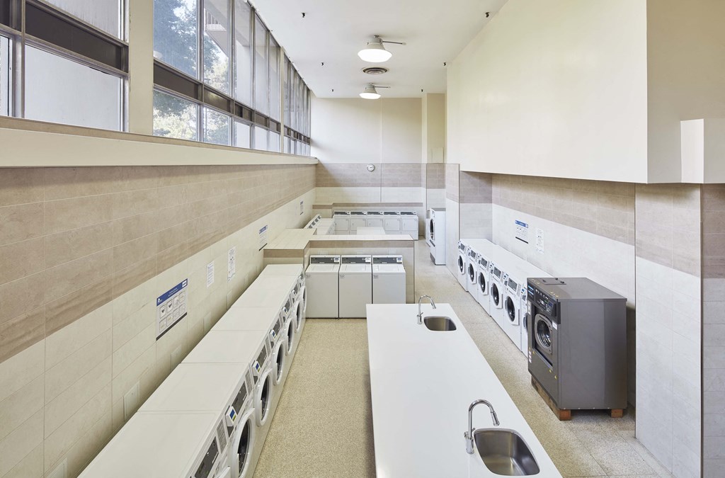 a large kitchen with white counter tops and a large window