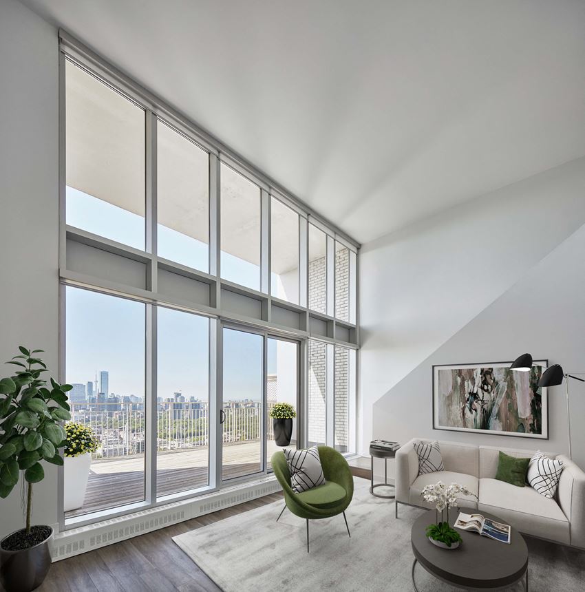 a living room with large windows and a couch and a chair