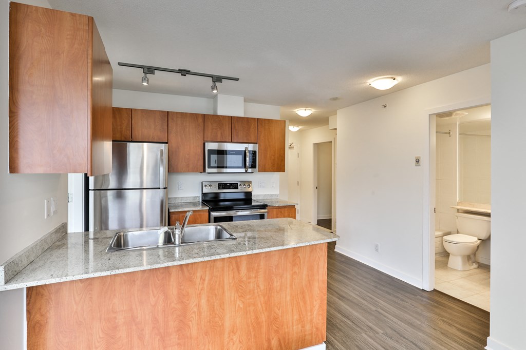 a spacious kitchen with stainless steel appliances and wooden cabinets