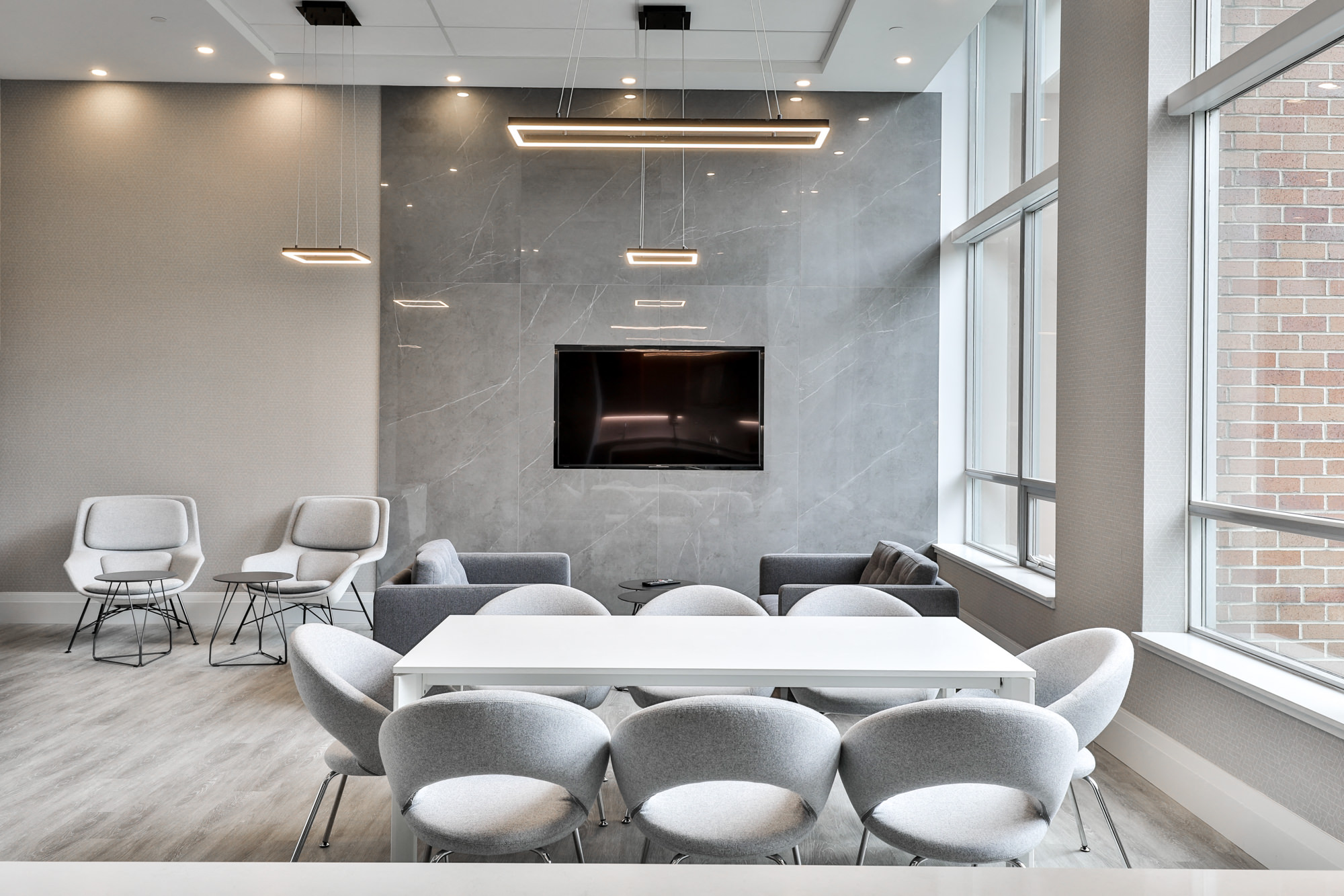 a conference room with a table and chairs and a tv on the wall