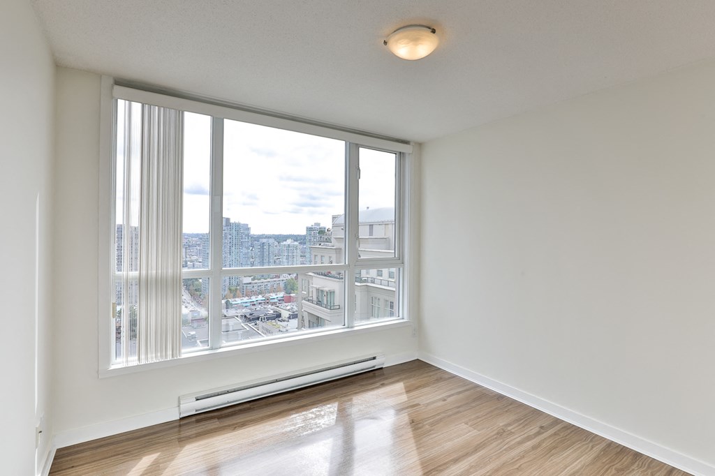 an empty living room with large windows and a city view